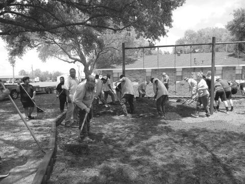 WORKING TOGETHER - On Friday, April 22, Mayor Ricky Fontenot, council members and several community volunteers worked together to replace the mulch at both town parks for the safety of the youth who will be utilizing the parks more during the coming the summer months. See more photos on Page 12. (Gazette photo by Heather Bogard)