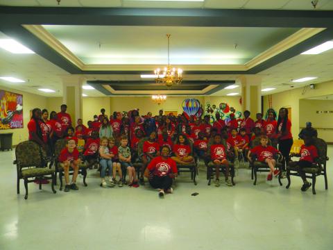 Astronaut in training Alyssa Carson and actor Eric Street pose with the students and staff of the Ville Platte Girls-Boys Place.