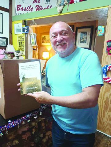 Darrel LeJeune shows off his newest book, a memoir about his late parents.