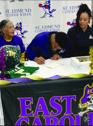 While flanked by family members, Ville Platte native Kieran Davis (center), signs his national letter of intent to play college football at East Carolina University. (Gazette photo by Rhett Manuel)