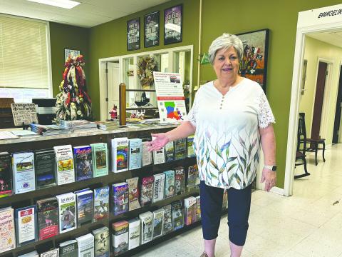 Debby Brunet, new executive director of Evangeline Parish Tourist Commission, shows off travel brochures and other items that are available inside the office, which is located on Main Street in Ville Platte. (Gazette photo by Heather Bogard)