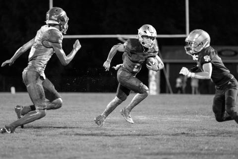 Trojan quarterback Ellis Fusilier (2) looks to pick up positive yardage in a win against Oakdale to open the football season. (Photo by Angela deVille)