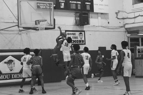 Mamou’s Tyrian Broussard (10) attempts to block a shot in the Green Demons’ game against Eunice. (Gazette photo by Rhett Manuel)