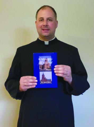 Father Jason Vidrine poses with a copy of his book The Religious History of the Vidrine Family. (Photo courtesy of Father Jason Vidrine)