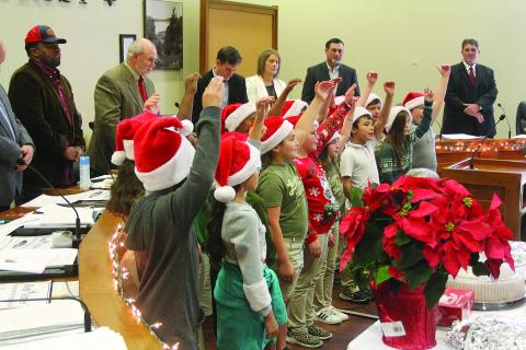 French Immersion students sing Christmas carols in French during the annual French meeting of the Evangeline Parish Police Jury held Tuesday, December 14. The students also led the Pledge of Allegiance in French. Pictured from left in the back are Police Jurors Ryan “LeDay” Williams and Eric Soileau, Secretary-Treasurer Donald Bergeron, and Police Jurors Leila Thrasher, Ryan Ardoin, and Kevin Veillon. (Gazette photo by Tony Marks)