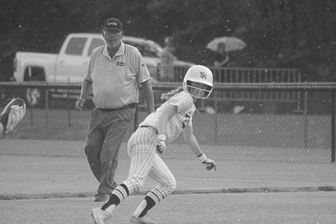 With the rain beginning to fall, Averie Pitre (7) attempts to get back safely to the first base bag in Sacred Heart’s playoff game against Glenbrook that was suspended on Tuesday. The game resumed on Wednesday at 2 p.m. (Gazette photo by Tony Marks)