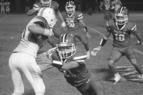 Basile’s Kye Smith (21) attempts to make a stop against a Hamilton Christian playmaker in the Bearcats’ 39-13 home loss against the Warriors. (Gazette photo by Tony Marks)