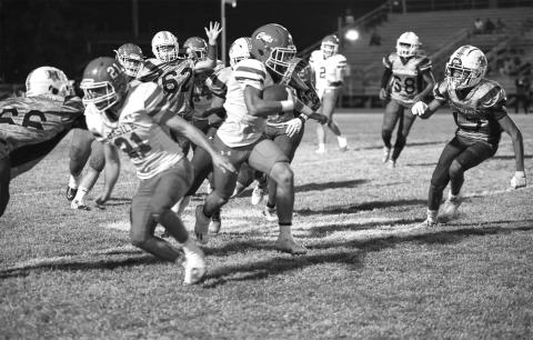 Basile’s Brian Hardy gallops past the Warrior line with some assistance from Kye Smith (21) during last week’s regular season finale. (Photo by Tonya Ortego)