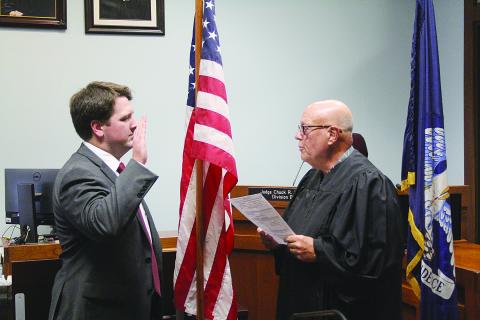 Chauncey Joseph (CJ) Hesnor (left) takes the oath of office from the honorable Judge Chuck West of the 13th Judicial Court. Hesnor was sworn-in as the newest assistant district attorney. (Gazette photo by Tony Marks)