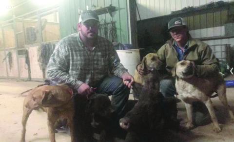Wacen Fontenot (left) is pictured with Garrett Soileau (right) and their dogs after a pig hunt in Gold Dust. (Photo courtesy of Wacen Fontenot)