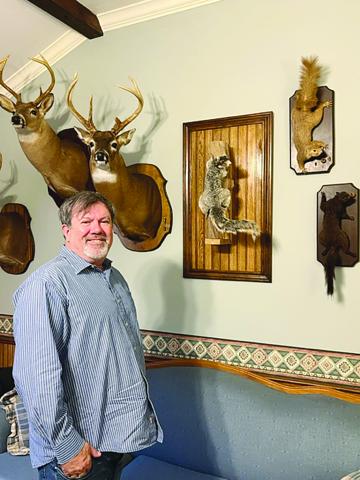 Ville Platte attorney Daniel Barzare is pictured with deer heads and squirrels that are mounted inside his law office. (Gazette photo by Tony Marks)