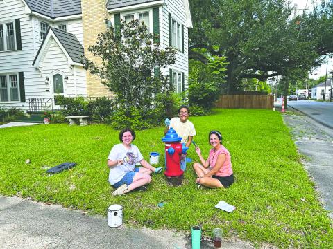 HYDRANTS GET A PATRIOTIC FACELIFT - From left, Kate LaCaze, Sarahi Sawtelle and Nina David are shown as they paint one of six fire hydrants along Magnolia Street. (Photo courtesy of Nina David)