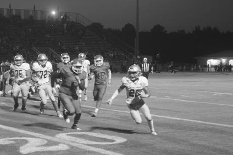 Trojan speedster Ike Perry (22) tries to elude a would-be tackler in Sacred Heart’s 13-0 loss to Caldwell Parish Thursday night. The Trojans now host Catholic-P.C. in a district contest. (Gazette photo by Tony Marks)