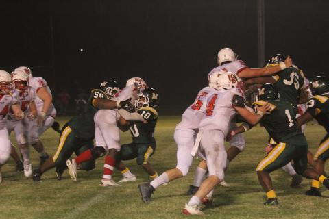 The stingy Mamou defense, led by Jaclarion Fontenot (58) and Christian Broussard (10), picks up a stop against Port Barre as the Green Demons earn a 43-12 victory. (Gazette photo by Tony Marks)