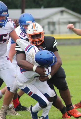 A Pine Prairie defensive player wraps up a Lake Arthur offensive player during the team’s scrimmage played last week in Pine Prairie. (Gazette photo by Rhett Manuel)
