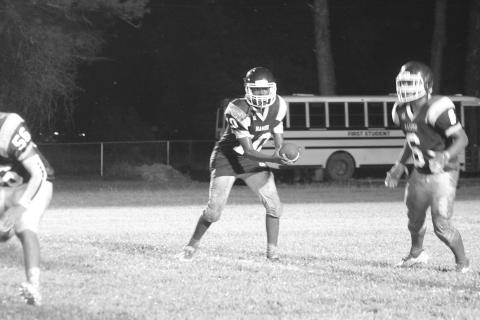Mamou’s Kaybren Weston (10) looks to hand the football off to a teammate in the Green Demons’ contest against Basile in the jamboree. (Gazette photo by Sylis Manuel)