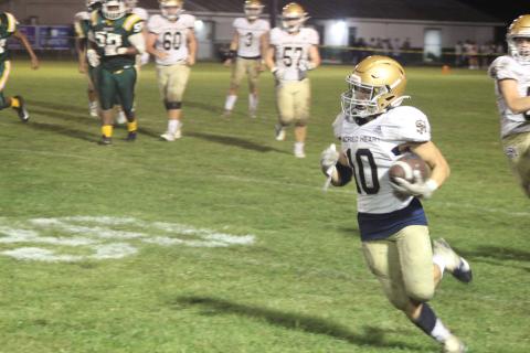 Sacred Heart’s Blake Hebert (10) picks up yardage on his career rushing night as the Trojans earned a 57-0 win over Mamou. (Gazette photo by Rhett Manuel)