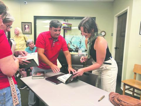 LARGE TURN OUT FOR BOOK SIGNING - Local author Jordan LaHaye Fontenot (right) signs copies of her new novel for David LaHaye. (Gazette photo by Heather Bogard)