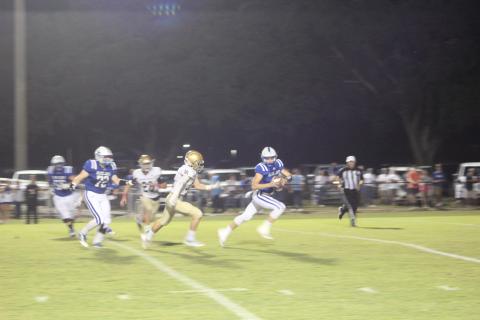 Ellis Shipp (14) tries to keep pace with St. Ed’s quarterback Luke Vidrine in the Trojans’ meeting with the Blue Jays in the regular season. That game was a 40-7 win for the visiting Trojans, and the two squads meet again in the playoff opener tomorrow night at Soileau-Landry Field. (Photo by Gazette photo by Rhett Manuel)