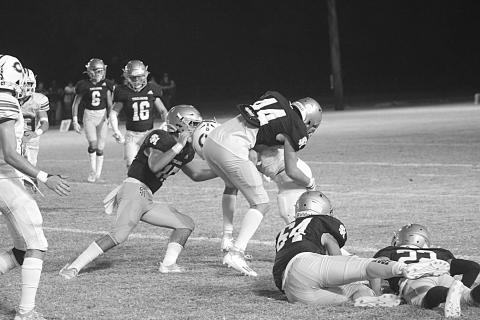 Defenders of Troy, led by Wade Pitre (15), combine for a stop against the Hornets of Catholic-Pointe Coupee in the teams’ district opener Thursday night. (Gazette photo by Rhett Manuel)
