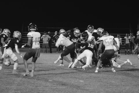 Abram Manuel (18) and others on the Sacred Heart defense combine for a stop against Westminster in the Trojans’ 31-24 home loss Thursday night. (Gazette photo by Tony Marks)