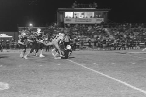A banged up Hayden Droddy (7) fights for yardage after getting tripped up by several Eagles from Holy Savior Menard. Droddy and the rest of his Sacred Heart Trojans moved to 4-0 after a 20-0 win Friday night. (Gazette photo by Tony Marks)