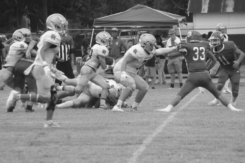 Jude Hebert (23) gets a block from a Trojan teammate and finds a running lane in Sacred Heart’s win against Basile in the opening contest of the jamboree. (Gazette photo by Rhett Manuel)