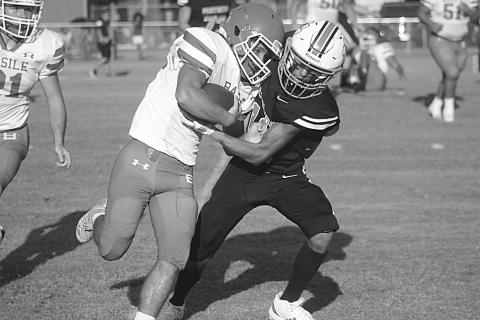 Pine Prairie’s Jayland Duplechin (13) looks to bring down Basile’s Logan Bergeron (22) in the first game of the jamboree. (Gazette photo by Tony Marks)