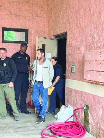 James “Jimbo” Fontenot is pictured in the center as he is transported from the Ville Platte Police Department to the Evangeline Parish Jail on Wednesday afternoon. He is escorted by officers Brandin Fontenot (left) and Darrian Guillory (right). Holding the door is Police Chief Al Perry Thomas (Gazette photo by Tony Marks)