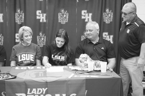 Sacred Heart’s Kali Shiver (second from left) puts pen to paper as she signs to play college basketball at LSU Eunice. Also pictured (from left) are her mother, Ashley Veillon; her father, James Shiver; and her head basketball coach, Craig Whittington. (Gazette photo by Tony Marks)