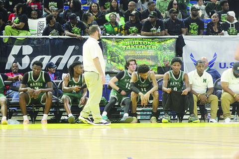 Mazzo Matteo (15) consoles Ernest Dugas (0) towards the end of Mamou’s loss to Marksville in the state semifinals on Wednesday night. Pictured between them is Braxton Ardoin (11), and standing is head coach Jaenne Fontenot. (Gazette photo by Tony Marks)