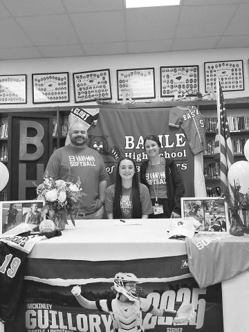 McKinley Guillory (seated) is flanked by Bearcat softball coaches Collins Barnes and Kristen Bacon during the recent letter of intent signing for the Basile High School softball senior.
