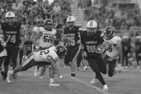 Cayden McCollough (10) runs past a diving Adarius Botley (12) and Mason Hazelton (56) from Oberlin. (LSN photo by Tony Marks)