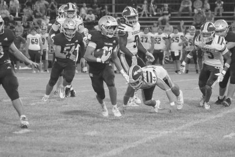 Trojan runner Gavin Patin (22) finds a running lane against the Oakdale Warriors in Sacred Heart’s season-opening 34-6 win at home Thursday night. (Gazette photo by Tony Marks)