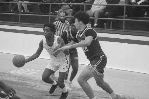 Mamou’s Shay Collins defends against Oakdale’s Leon Posey V (2) in the Green Demons’ 65-63 win against the Warriors last Friday night. (Gazette photo by Tony Marks)