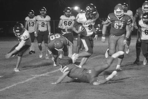 A diving Pierson Comeaux (14) attempts to make a tackle on a leaping Jayden Bokemeyer (9) during Basile’s 26-0 win over Oberlin on Halloween night. (Gazette photo by Tony Marks)