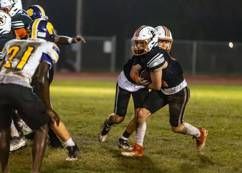 Logan Vidrine (11) takes the ball from Caden Rollins and goes on to score a 10-yard touchdown in Pine Prairie’s 42-6 loss against Ville Platte High. (Photo by Abby Reed)
