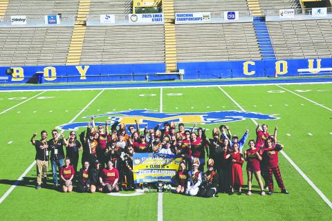 The Pine Prairie High School Marching Band recently ended their season on a high note by capturing  the LMEA State Championship for second year in a row. The group, in the above photo, gathers around the championship banner. (Photo courtesy of Lynette Hazelton)
