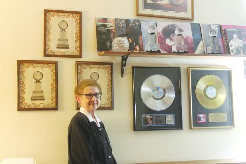 Retired Evangeline Parish School Board Member Peggy Forman stands alongside her platinum and gold records and other items from her career in Country music. (Gazette photo by Tony Marks)