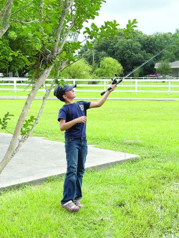 Liam Darbonne, son of Paula and Mayor Justin Darbonne, of Chataignier, casts his line into the village’s fishing pond. (Gazette photo by Tony Marks)