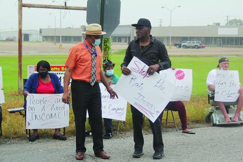 Ville Platte City Councilman Lionel Anderson (left) discusses issues with one of the protest organizers Donald Anderson (right) at the event held outside of the Cleco office in Ville Platte. (Gazette photo by Tony Marks)