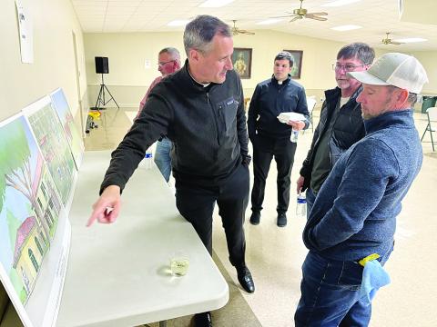 Fr. J. Patrick Hough, S.J., the new executive director of Grand Coteau Retreats, is pictured on the left as he points out proposed renderings of the new master plan of Our Lady of the Oaks Retreat House and St. Charles College. Also pictured, from left, are Fr. Alex Lançon, parochial vicar of Sacred Heart of Jesus Catholic Church; Mickey Johnson; and Jay Johnson. (Gazette photo by Tony Marks)