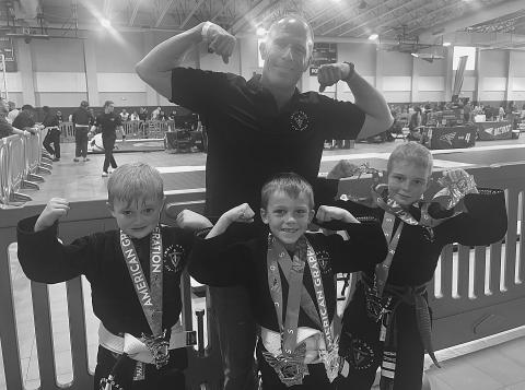 STUDENTS DO WELL IN TOURNAMENT - Standing in front, from left, Inner Game Jiu-Jitsu students Ian Mire, Weston Fontenot and Charlie Stevens excelled in a recent tournament held in New Orleans. They are shown with their proud coach Robbie Stevens, standing in back. (Photo courtesy of Robbie Stevens)