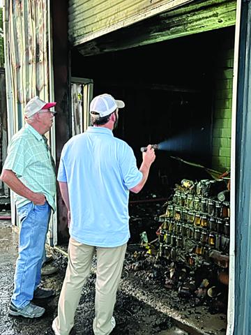 Kary LaFleur (left) and son, Ross, inspect the damage caused by a fire at Kary’s Roux in Ville Platte. According to Fire Chief Chris Soileau, the cause of the fire remains under investigation. (Gazette photo by Tony Marks)
