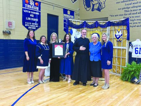 PRESTIGIOUS AWARD PRESENTED - During homecoming festivities on Friday, November 7, Sacred Heart School received the Cognia School of Distinction honor. Shown, from left, are Kylie LaHaye, high school curriculum coordinator; Jodi Andrus, elementary curriculum coordinator; Dawn Shipp, high school principal; Danielle Ardoin, elementary principal; Father Mitchell Guidry, pastor; Anna Larriviere, Superintendent of the Diocese of Lafayette Catholic Schools; and Sadie Fontenot, high school guidance counselor. 