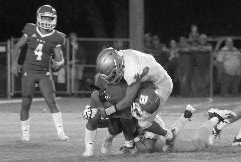 The Sacred Heart Trojan defense swarms over Basile High running back Ethan Bazinet (5) before he can gain any positive yardage. The Trojans throttled the Bearcat offense the entire game last season, holding Basile to 18 total yards in a 28-0 win. (Gazette file photo)
