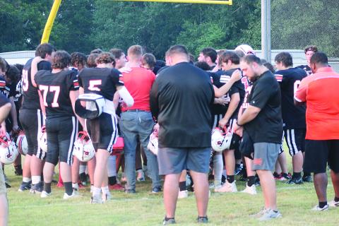 The Pine Prairie Panthers have a moment of prayer after a scrimmage against the Basile Bearcats on Thursday, August 22. Pictured in the front are head coach Lance Meyers (left) and assistant coach Hunter David (right). (Gazette photo by Tony Marks)