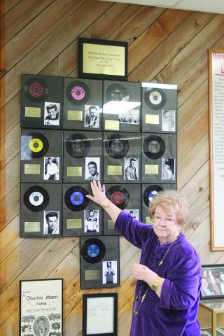 Sharon Fontenot is pictured as she points out the 13 Swamp Pop records which were Billboard and Cashbox chart hits of the 1950s and 1960s. By comparison, Cajun music had two songs to hit the charts, while Zydeco had one song to make the charts. (Gazette photo by Tony Marks)