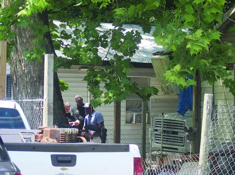 Ville Platte Chief of Police A. Perry Thomas (center) and other law enforcement officers investigate evidence collected at the scene of a fatal shooting in Ville Platte on Monday, May 4. (Gazette photo by Tony Marks)