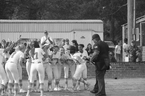 Josie Vidrine (12) celebrates at home plate with her Pine Prairie teammates after delivering a game-tying home run against South Beauregard on Monday. (Gazette photo by Tony Marks)